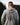 Back view of man outdoors wearing gray Campfire Nights hoodie with mountain and campfire graphic, casual sweatshirt for camping, hiking, and outdoor adventures