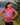 Young girl wearing a magenta Adventure in Every Letter  t-shirt from the Wake Up. Rock Life. Repeat. collection, standing outdoors with mountains and trees in the background. Inspired by Kodiak Island but designed for kids who love outdoor adventures anywhere.