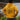 Back view of youth wearing heather mustard Campfire Nights full zip hoodie with campfire and mountain graphic, standing outdoors near water, perfect for camping trips