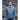 Man wearing blue Wake Up Rock Life Repeat long sleeve shirt on rocky Kodiak Alaska shoreline – island life and adventure apparel