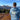 Person wearing Trail to the Catch Full Zip Hoodie in steel blue, back view outdoors with mountains in background, showcasing fishing and adventure lifestyle